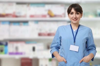 Image of Positive pharmacist in uniform at drugstore. Space for text