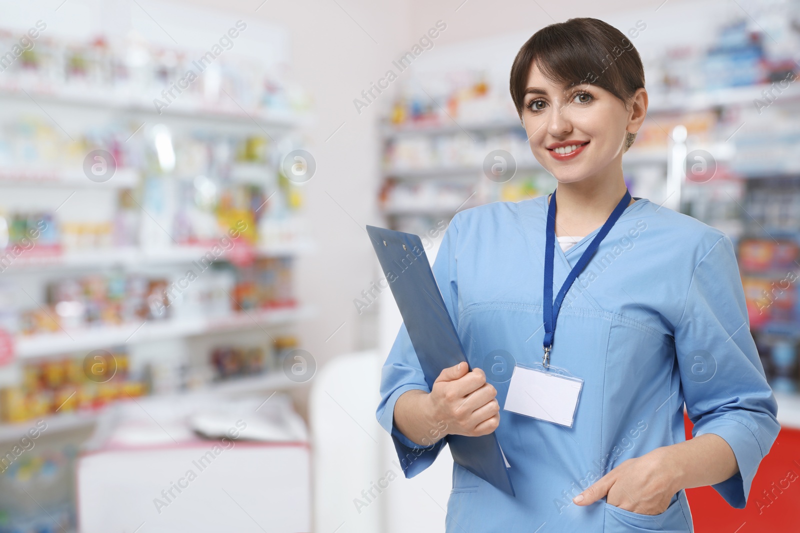 Image of Positive pharmacist in uniform at drugstore. Space for text