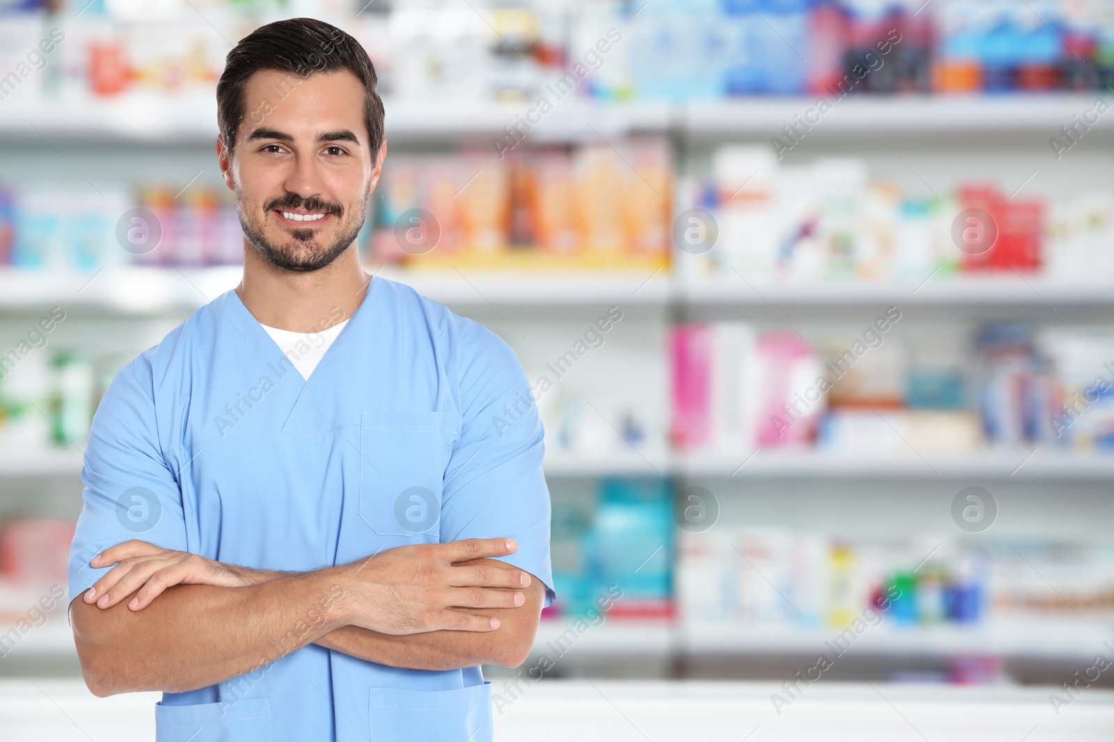 Image of Positive pharmacist in uniform at drugstore. Space for text