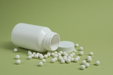 Photo of Homeopathic remedy and bottle on light green background. Space for text