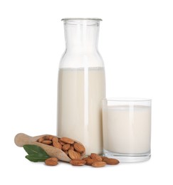 Glass of almond milk, jug and almonds isolated on white