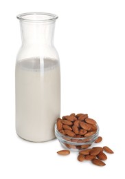 Glass jug of almond milk and almonds isolated on white