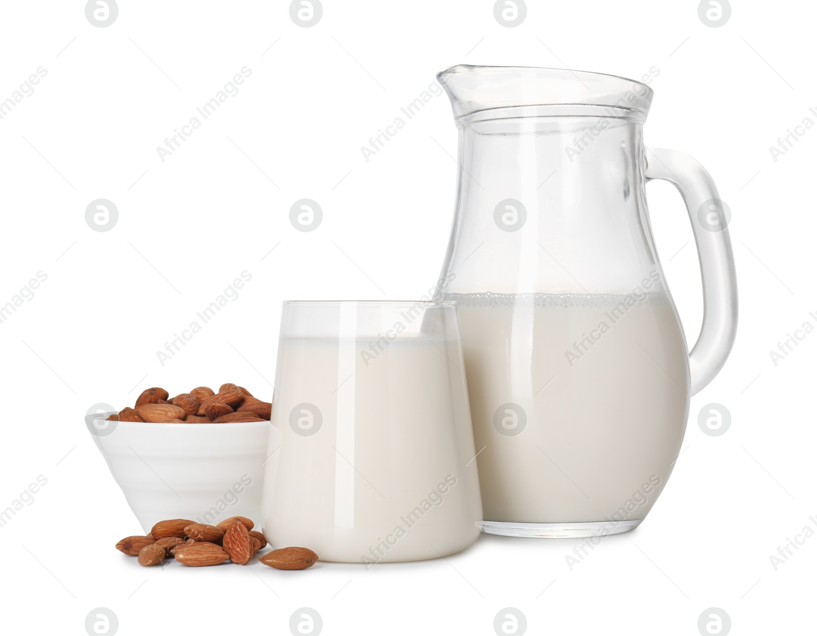 Photo of Glass of almond milk, jug and almonds isolated on white