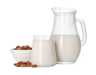 Glass of almond milk, jug and almonds isolated on white