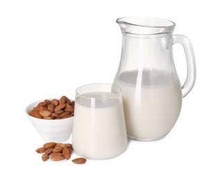 Glass of almond milk, jug and almonds isolated on white