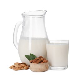 Photo of Glass of almond milk, jug and almonds isolated on white