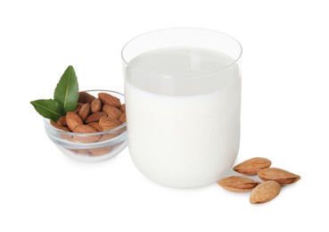 Glass of almond milk and almonds isolated on white