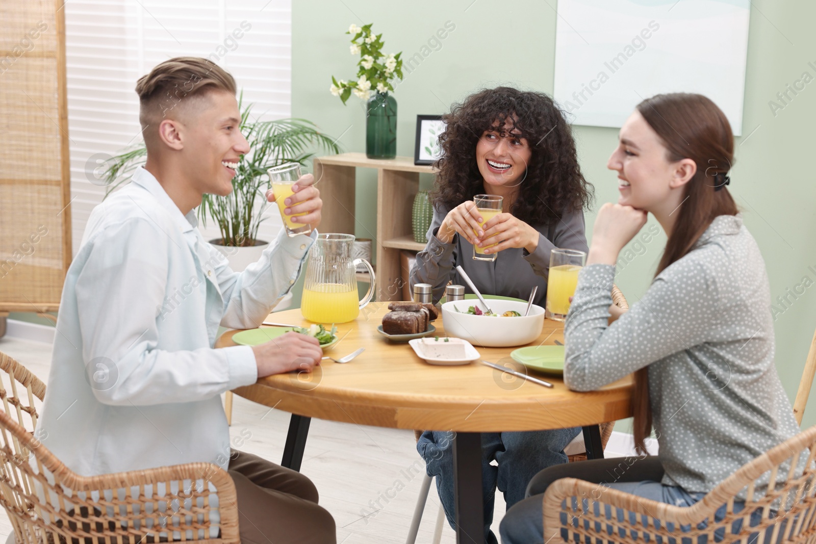 Photo of Happy friends having vegetarian meal in cafe