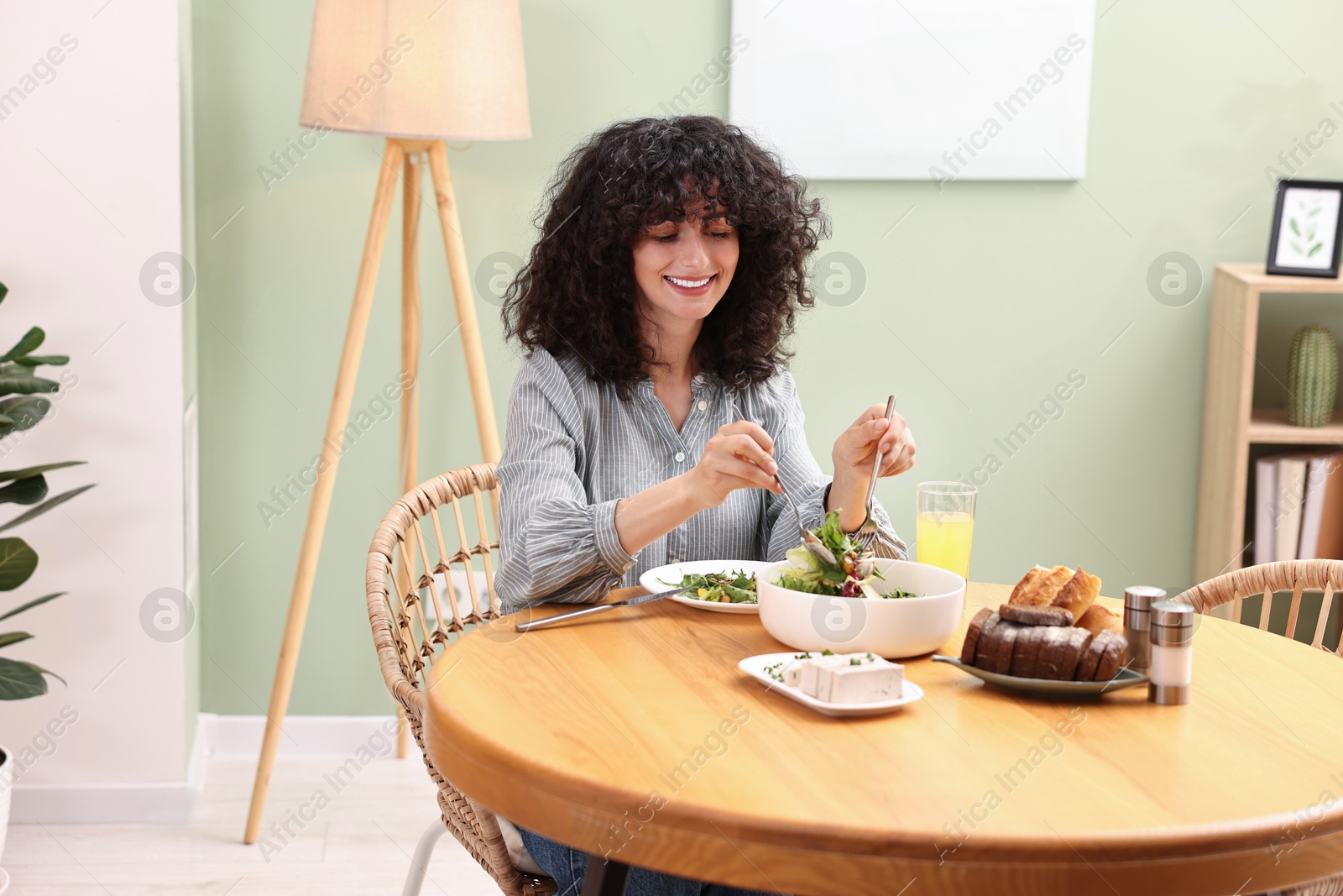 Photo of Woman having vegetarian meal at table in cafe