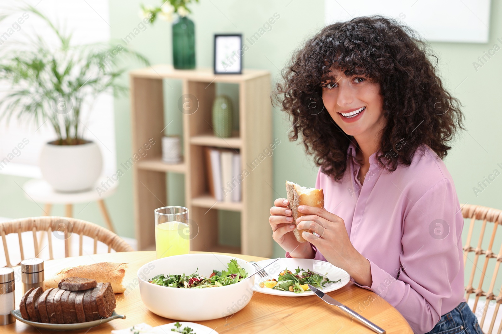 Photo of Woman having vegetarian meal at table in cafe