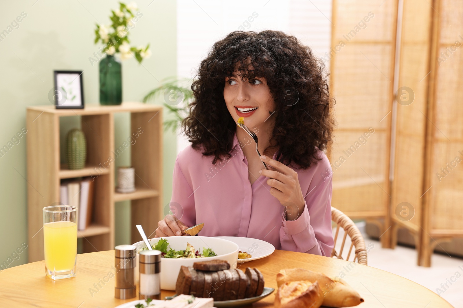 Photo of Woman having vegetarian meal at table in cafe