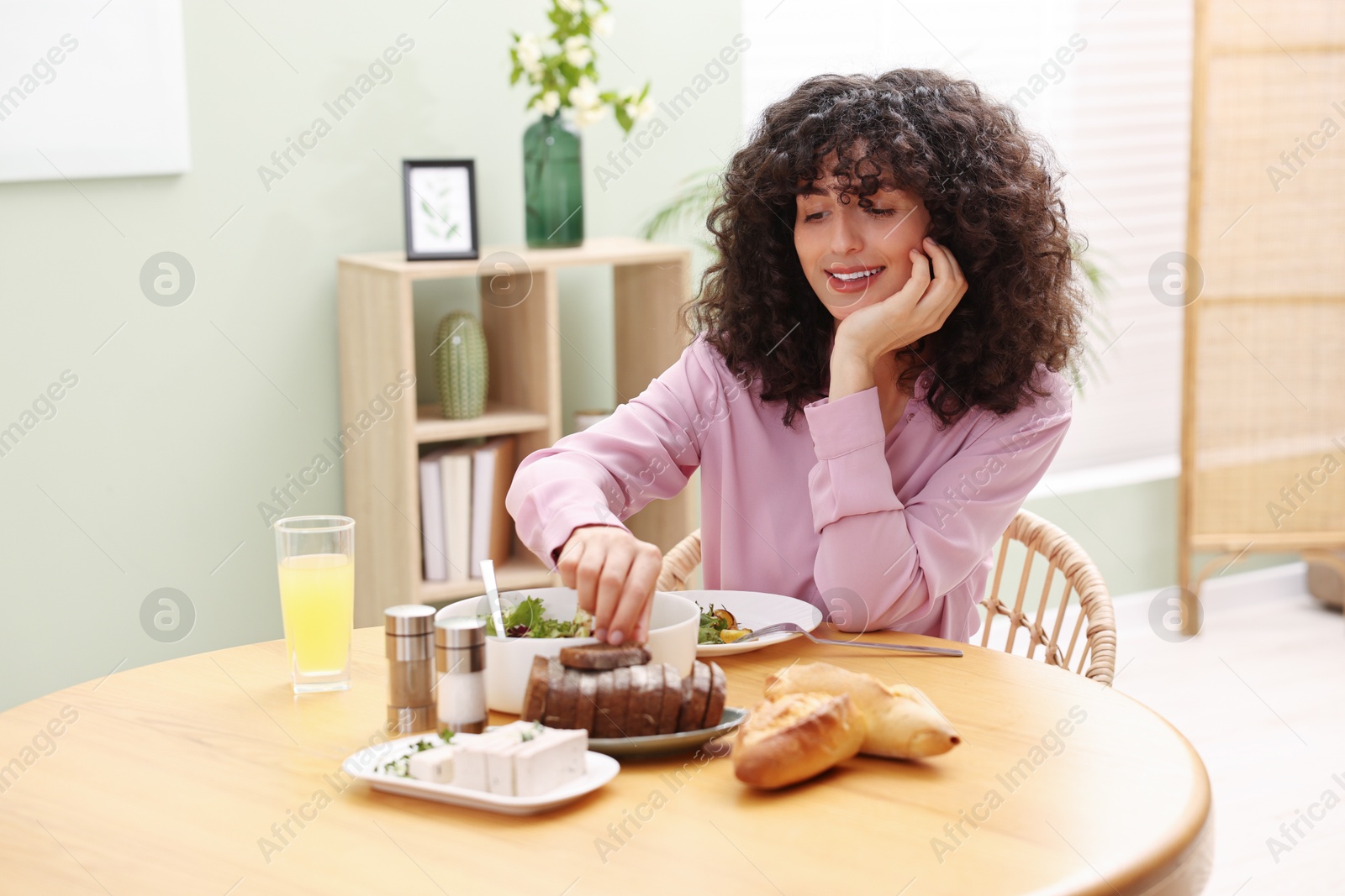 Photo of Woman having vegetarian meal at table in cafe