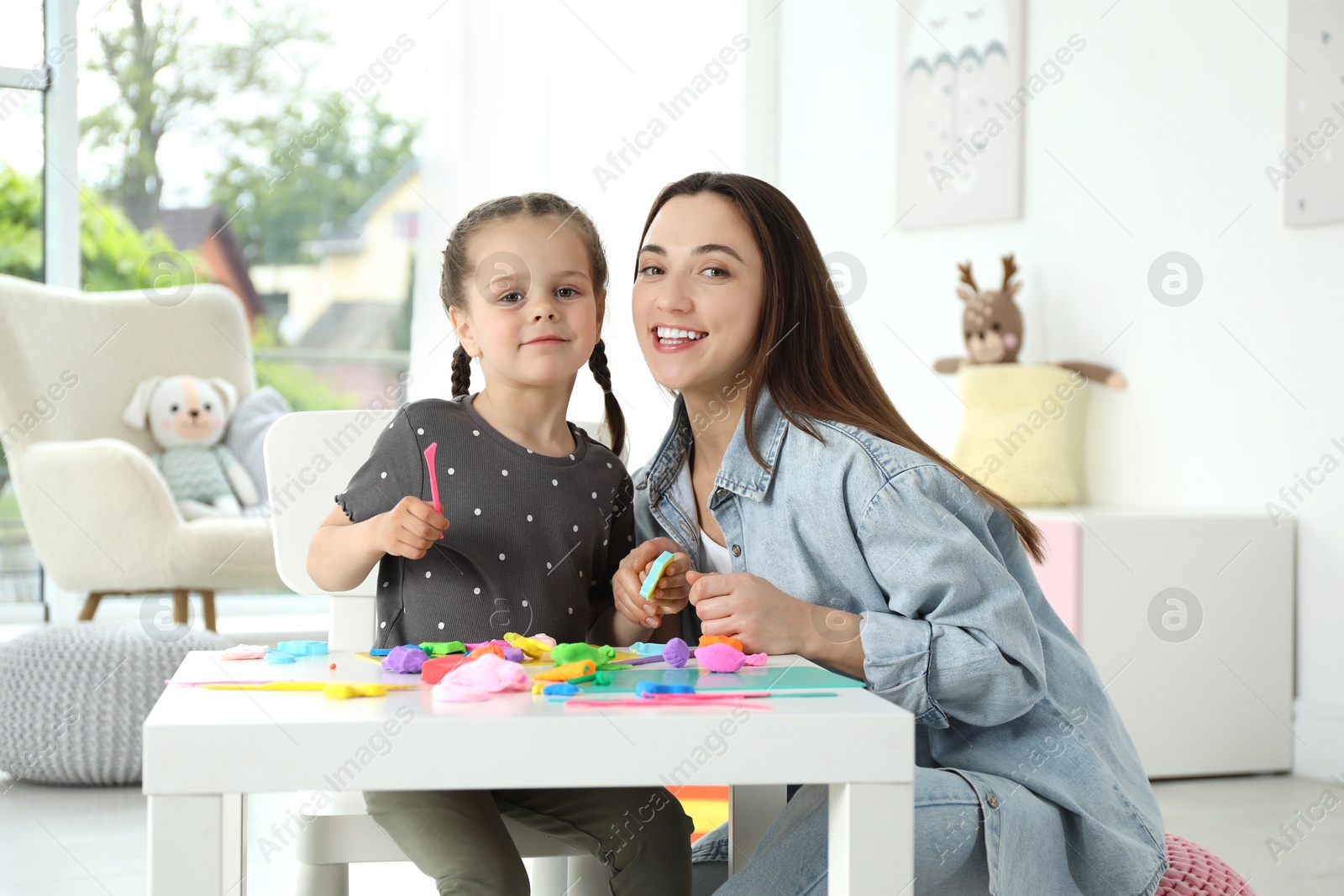 Photo of Play dough activity. Family portrait of smiling mother with her daughter at home