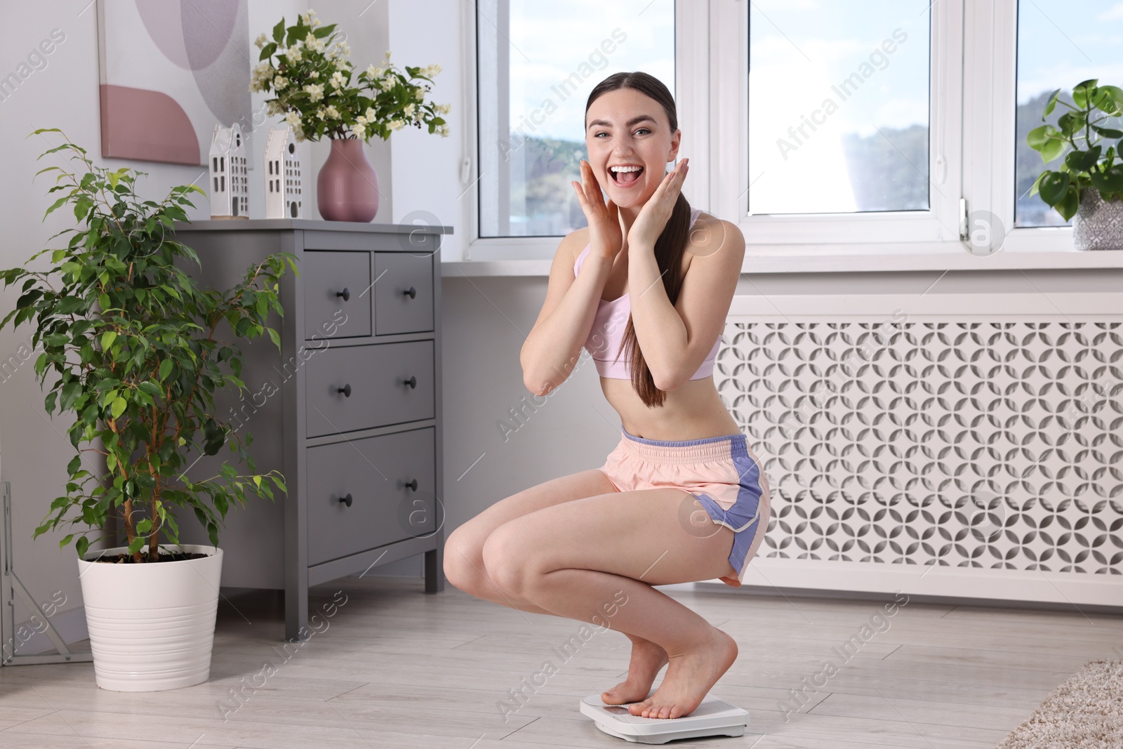 Photo of Happy woman on floor scale at home