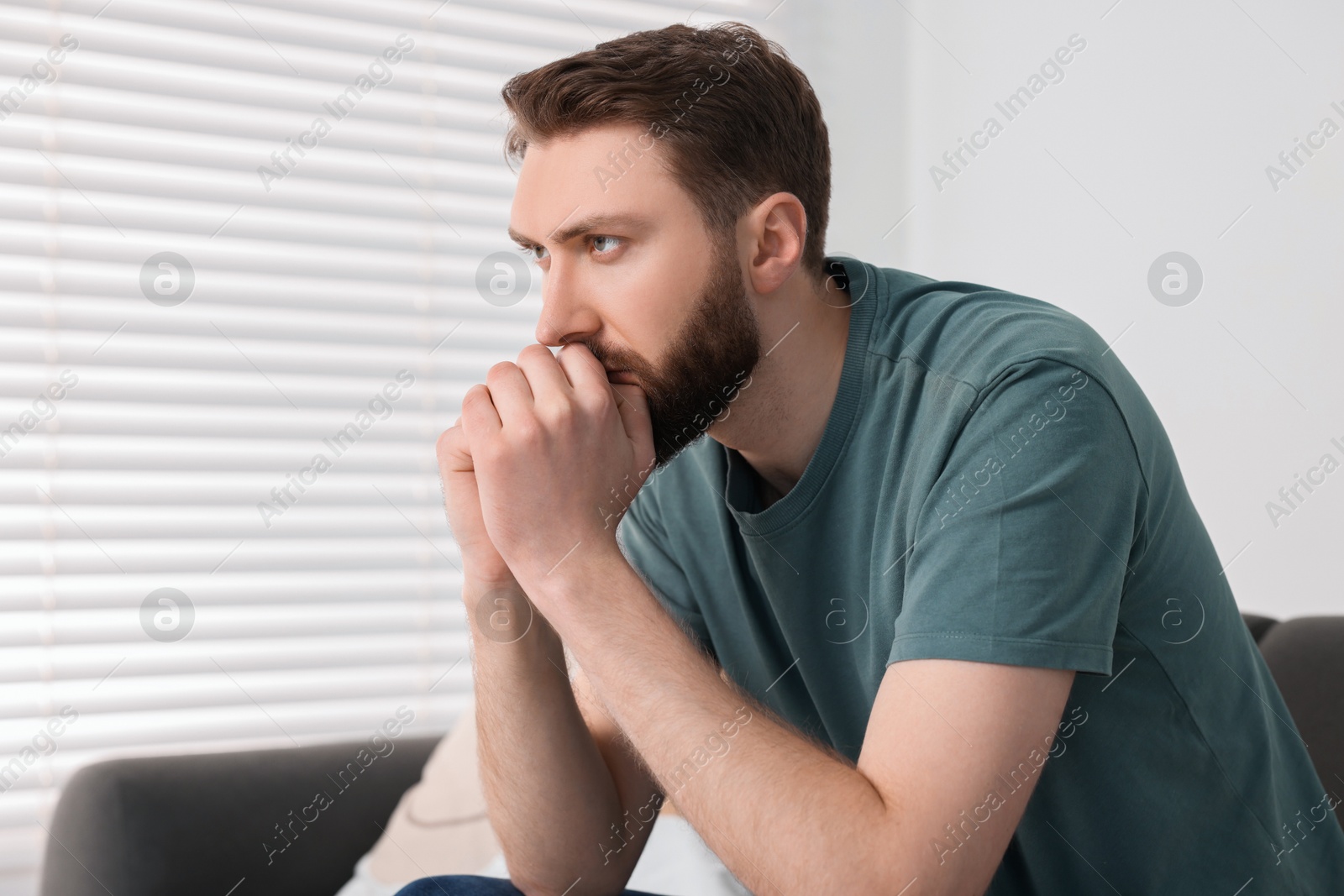 Photo of Loneliness concept. Sad man sitting on sofa at home