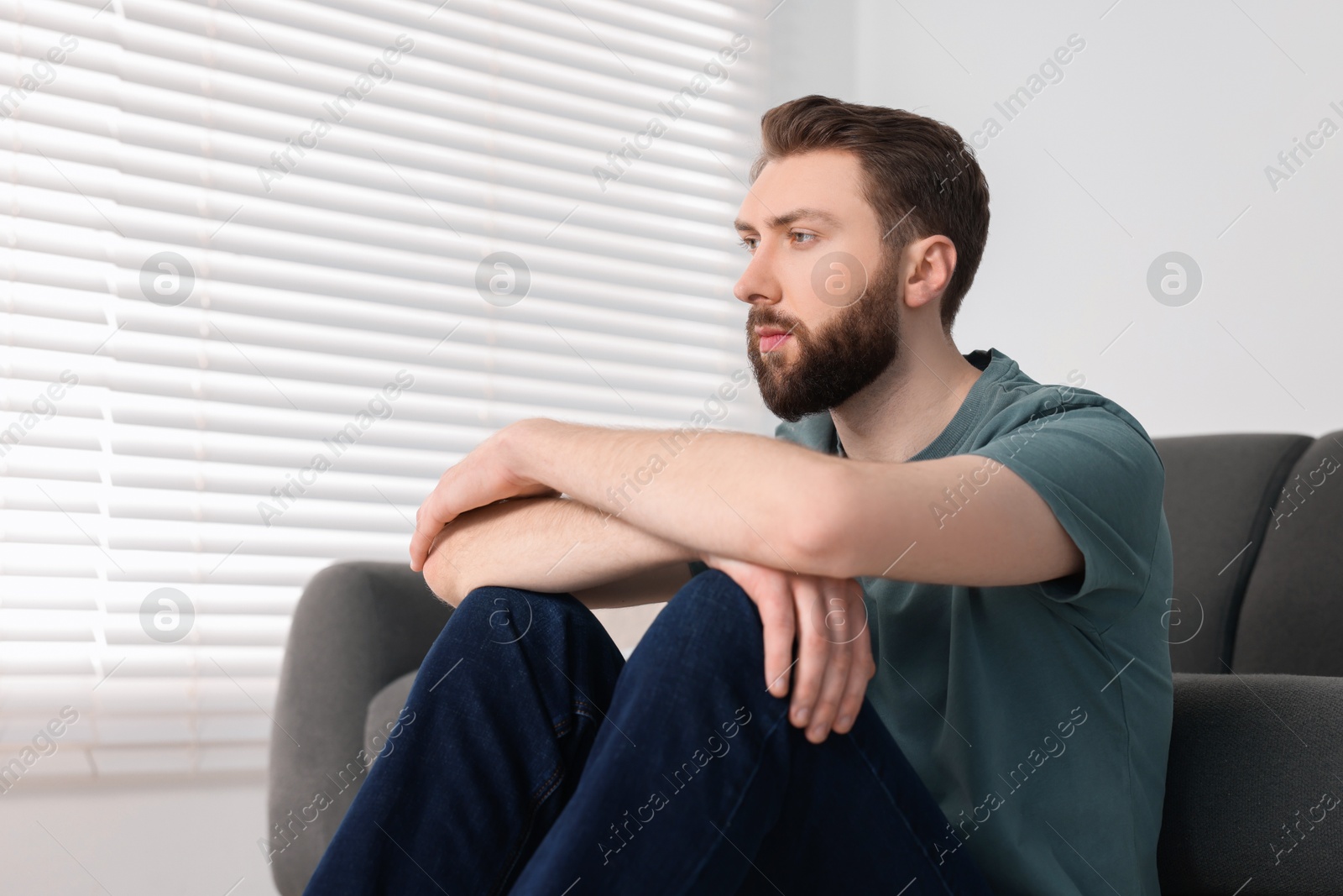 Photo of Loneliness concept. Sad man sitting on floor at home