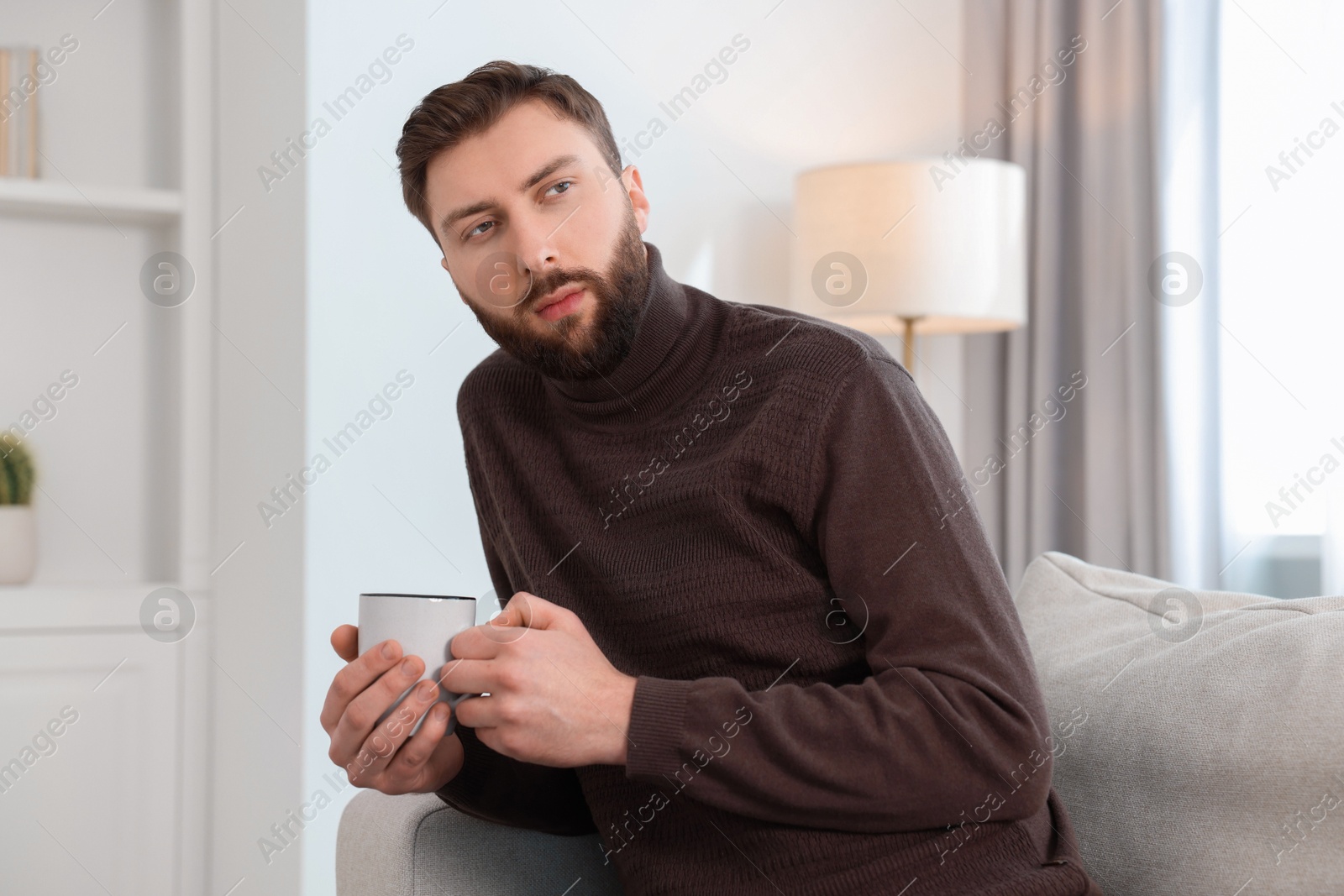 Photo of Loneliness concept. Sad man sitting on sofa at home