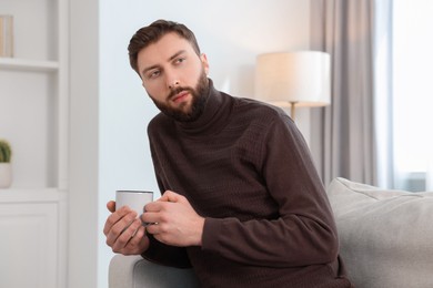 Photo of Loneliness concept. Sad man sitting on sofa at home