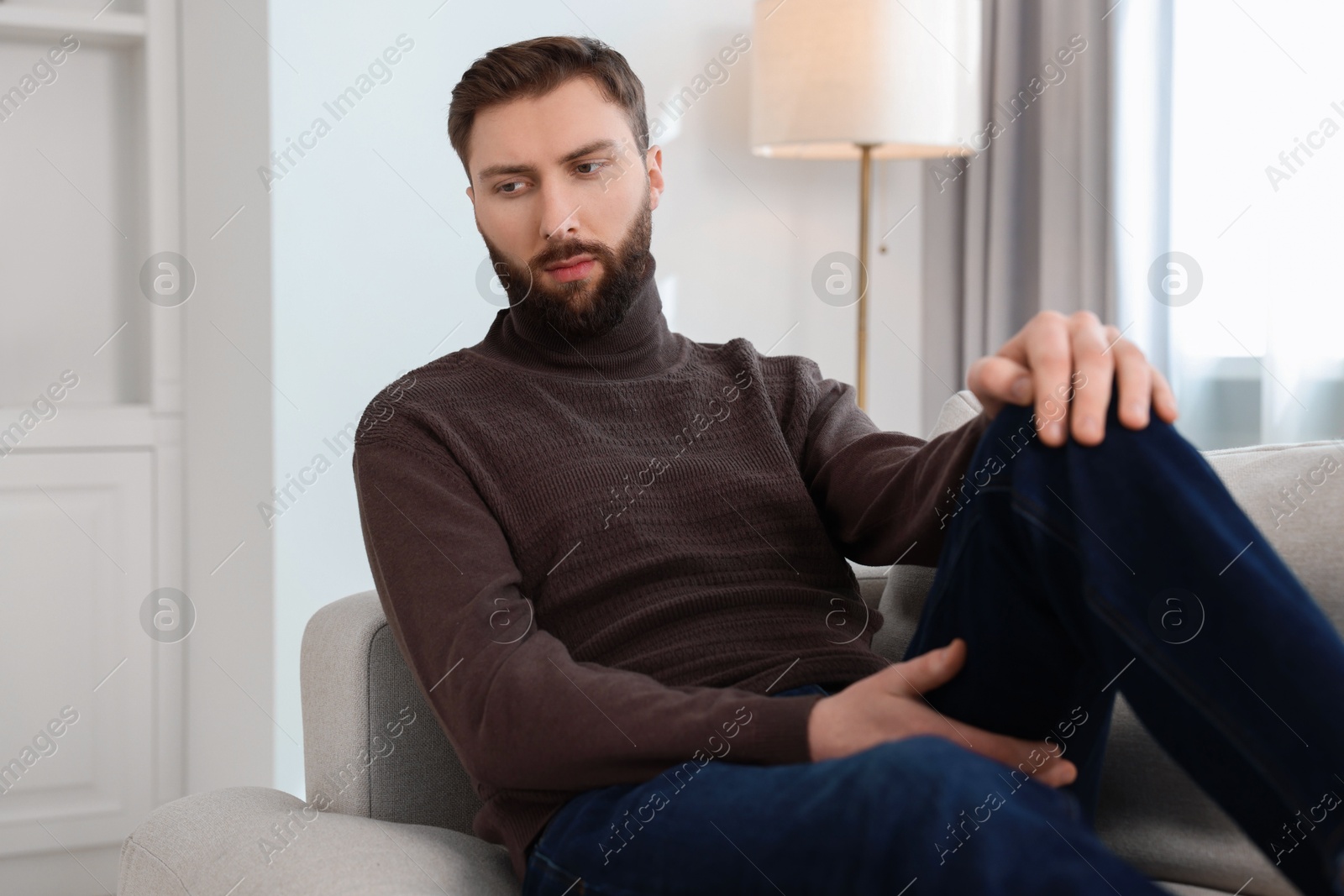 Photo of Loneliness concept. Sad man sitting on sofa at home