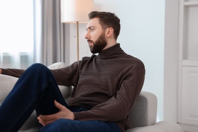 Photo of Loneliness concept. Sad man sitting on sofa at home