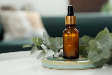 Aromatherapy. Bottle of essential oil and eucalyptus leaves on table