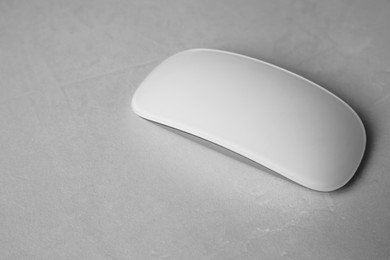Photo of One wireless mouse on light textured table, closeup. Space for text
