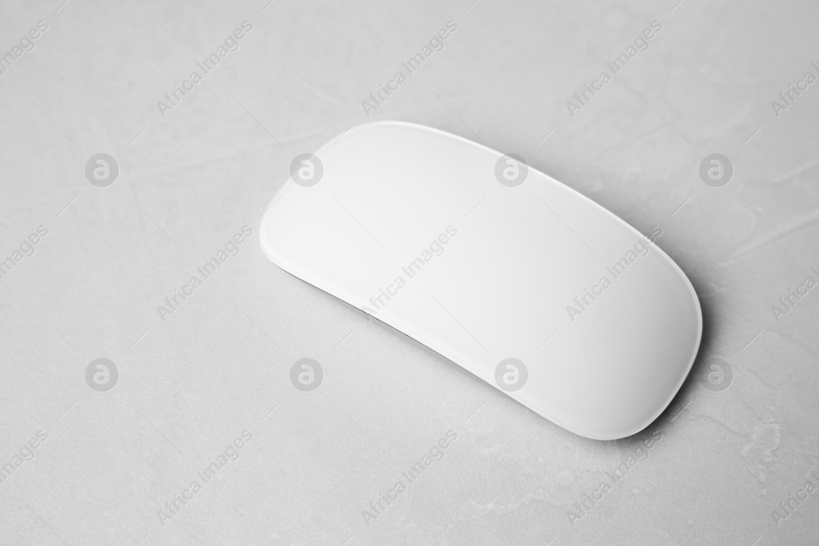 Photo of One wireless mouse on light textured table, closeup. Space for text