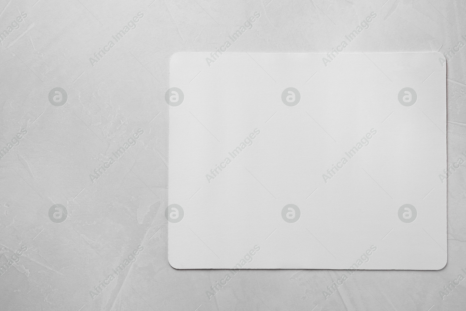 Photo of One mouse pad on grey textured table, top view. Space for text