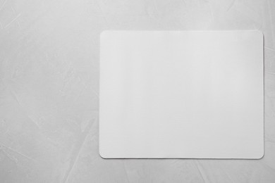 One mouse pad on grey textured table, top view. Space for text