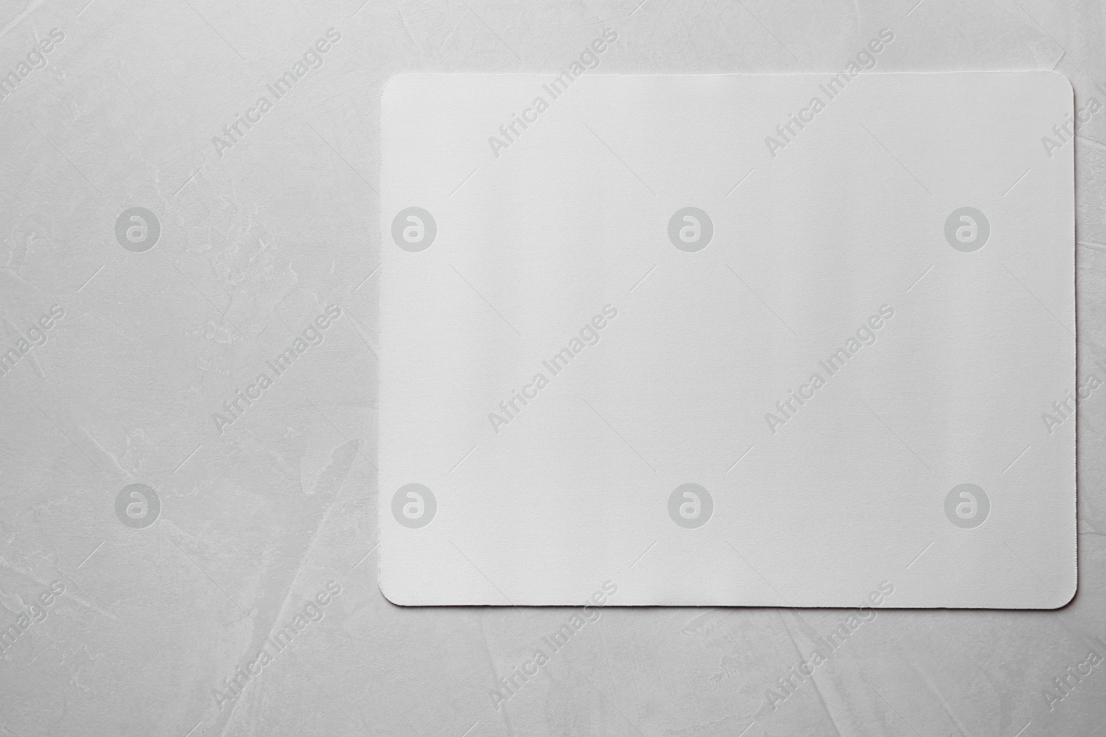 Photo of One mouse pad on grey textured table, top view. Space for text