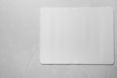 Photo of One mouse pad on grey textured table, top view. Space for text