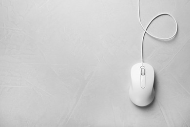 Photo of Wired mouse on grey textured table, top view. Space for text