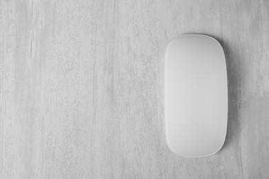 Photo of One wireless mouse on grey wooden table, top view. Space for text