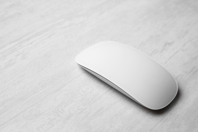 Photo of One wireless mouse on grey wooden table, closeup. Space for text