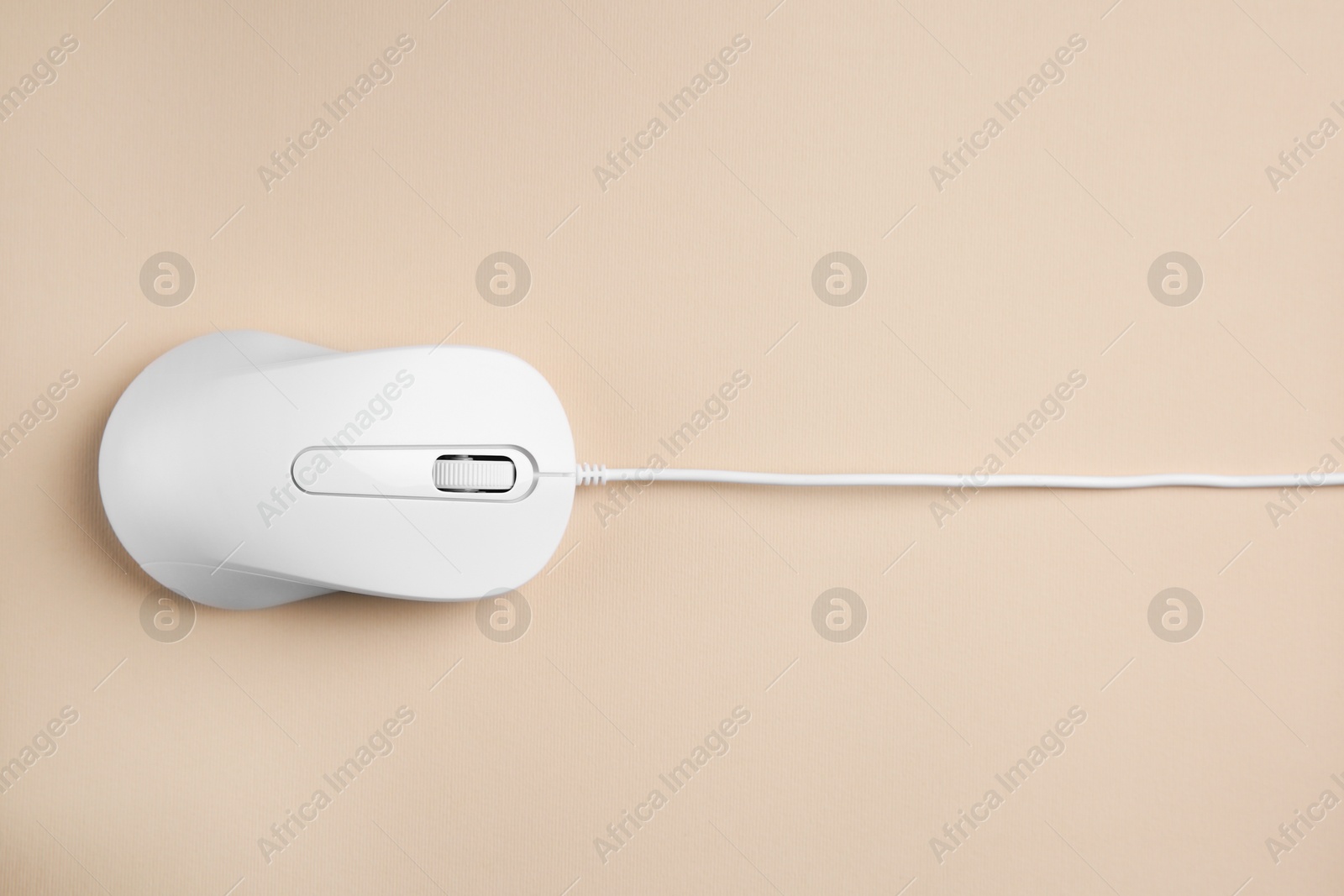 Photo of One wired mouse on beige background, top view