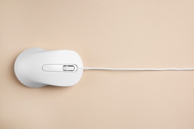 Photo of One wired mouse on beige background, top view