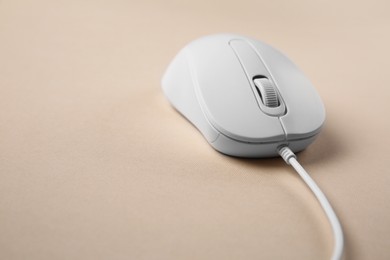 Photo of One wired mouse on beige background, closeup. Space for text