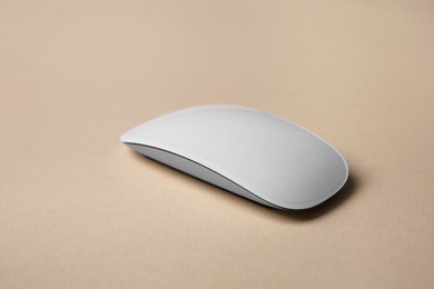 Photo of One wireless mouse on beige background. Space for text