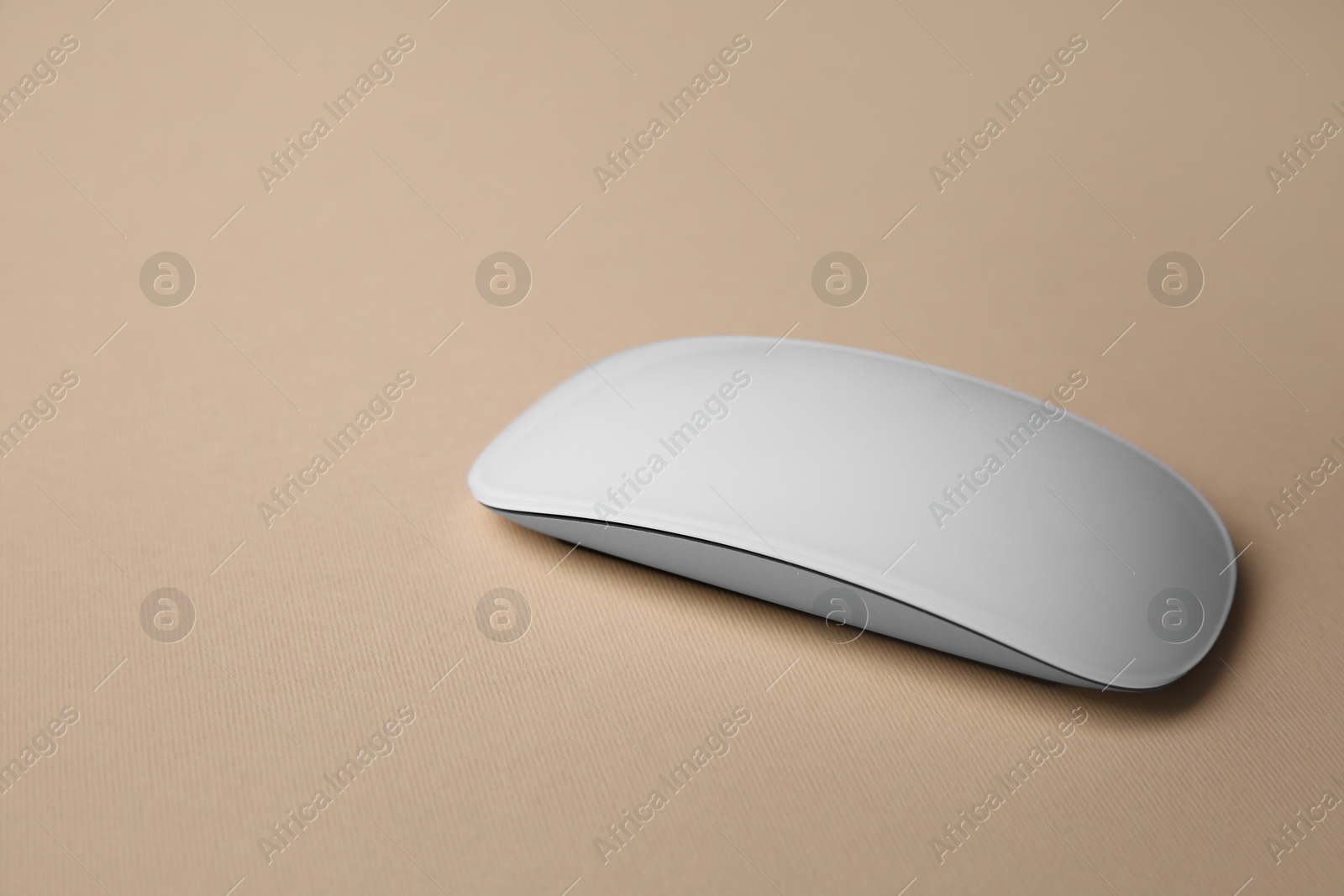 Photo of One wireless mouse on beige background, closeup. Space for text