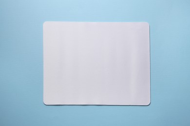 One mouse pad on light blue background, top view. Space for text