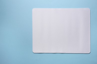 Photo of One mouse pad on light blue background, top view. Space for text