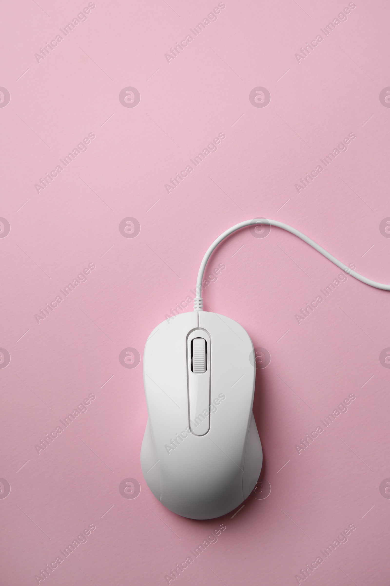 Photo of One wired mouse on pink background, top view