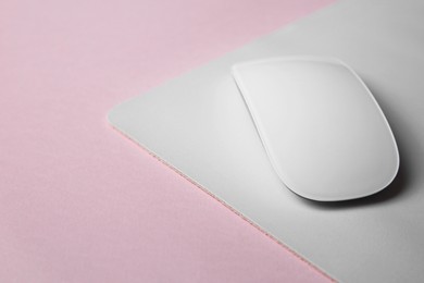 One wireless mouse with mousepad on pink background, closeup. Space for text