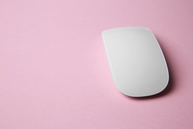 Photo of One wireless mouse on pink background. Space for text