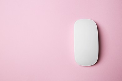 One wireless mouse on pink background, top view. Space for text