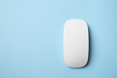 Photo of One wireless mouse on light blue background, top view. Space for text