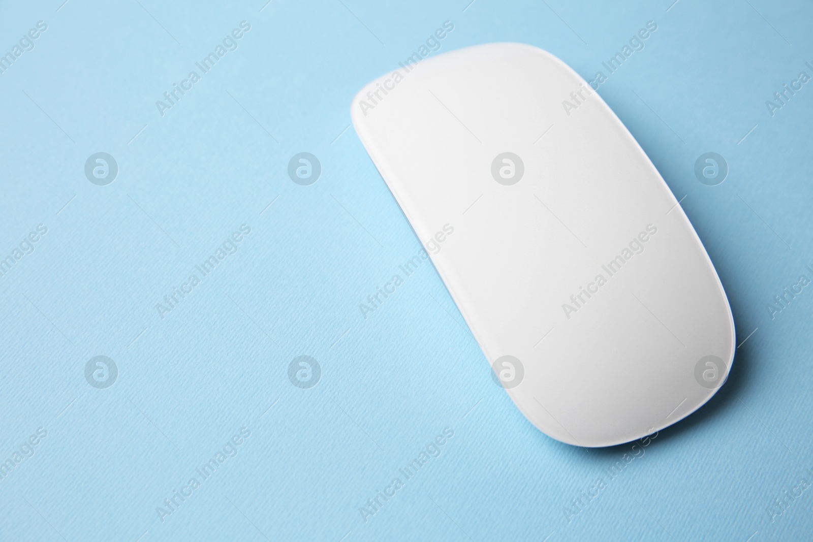 Photo of One wireless mouse on light blue background. Space for text