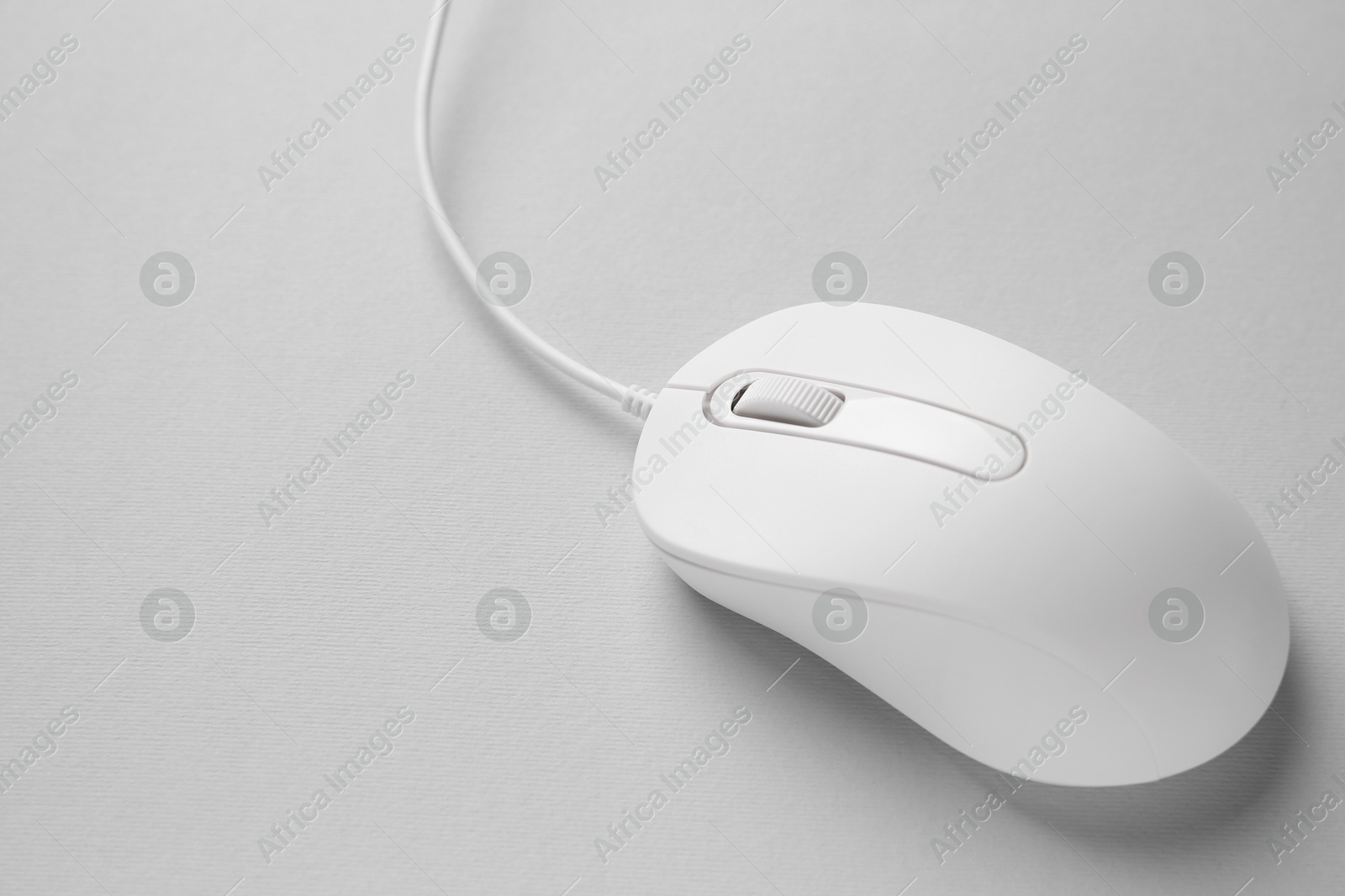 Photo of One wired mouse on grey background, closeup. Space for text