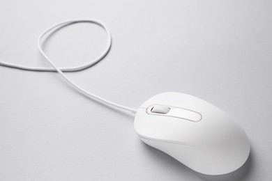 Photo of One wired mouse on grey background, closeup