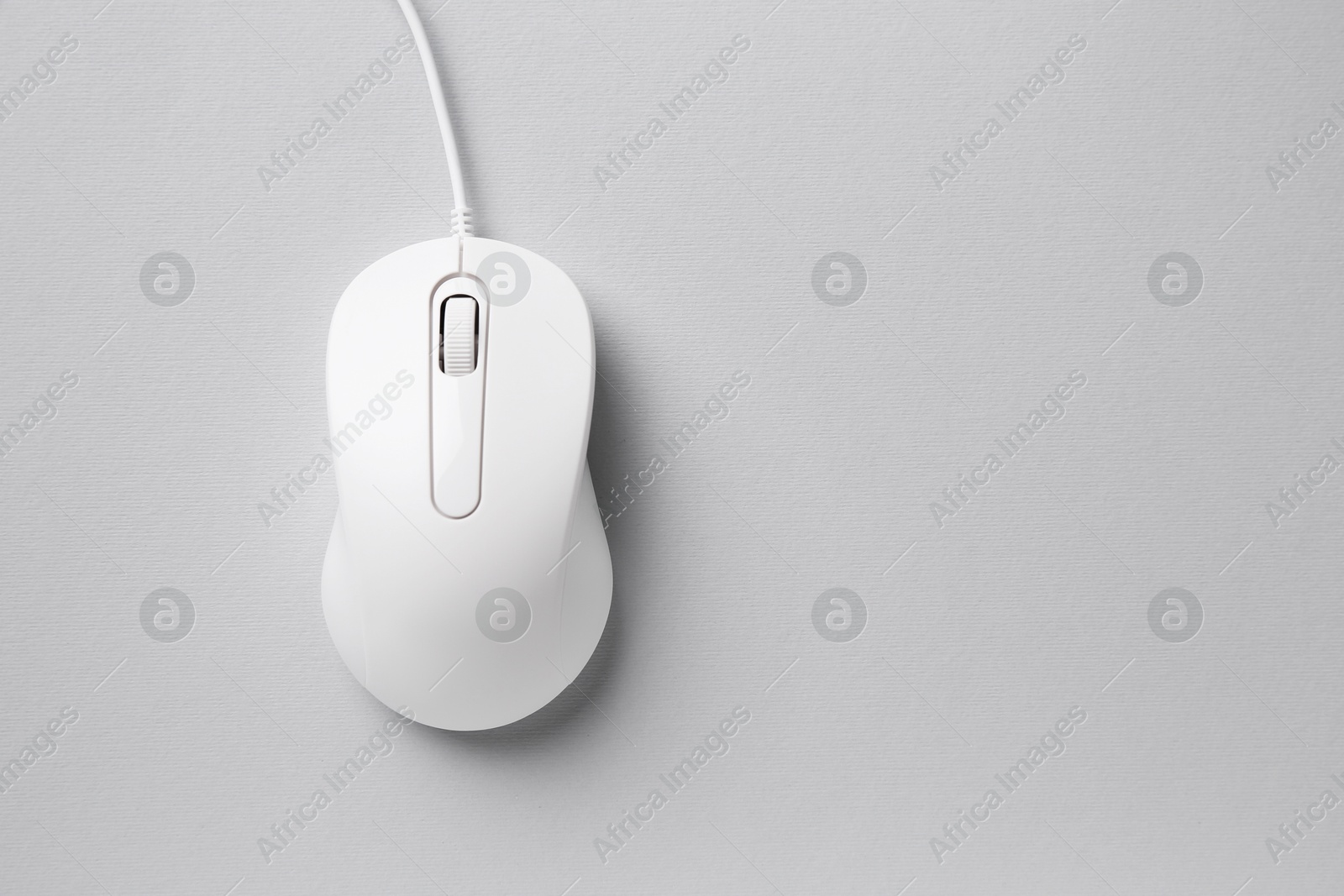 Photo of One wired mouse on grey background, top view. Space for text